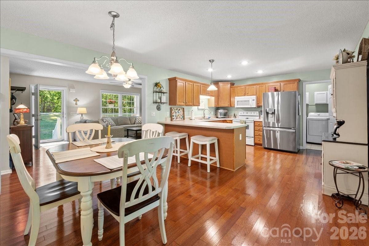 Another view of the kitchen and dining area with the laundry room visible at the back. - 104 Balsam Circle, Troy