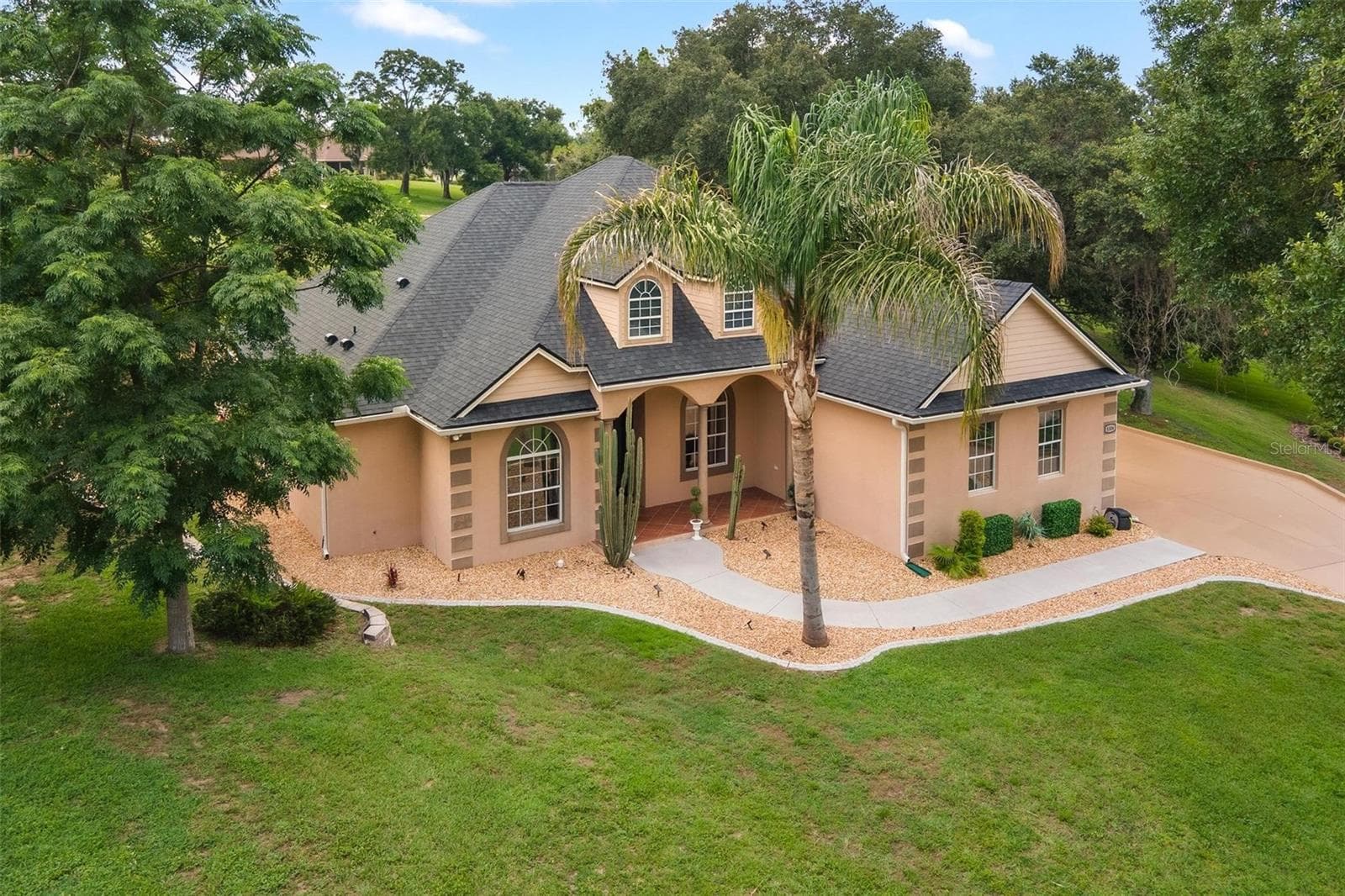 Take in the full beauty of the property from above, surrounded by mature trees and well-maintained landscaping. - 5506 CITATION CT, LADY LAKE