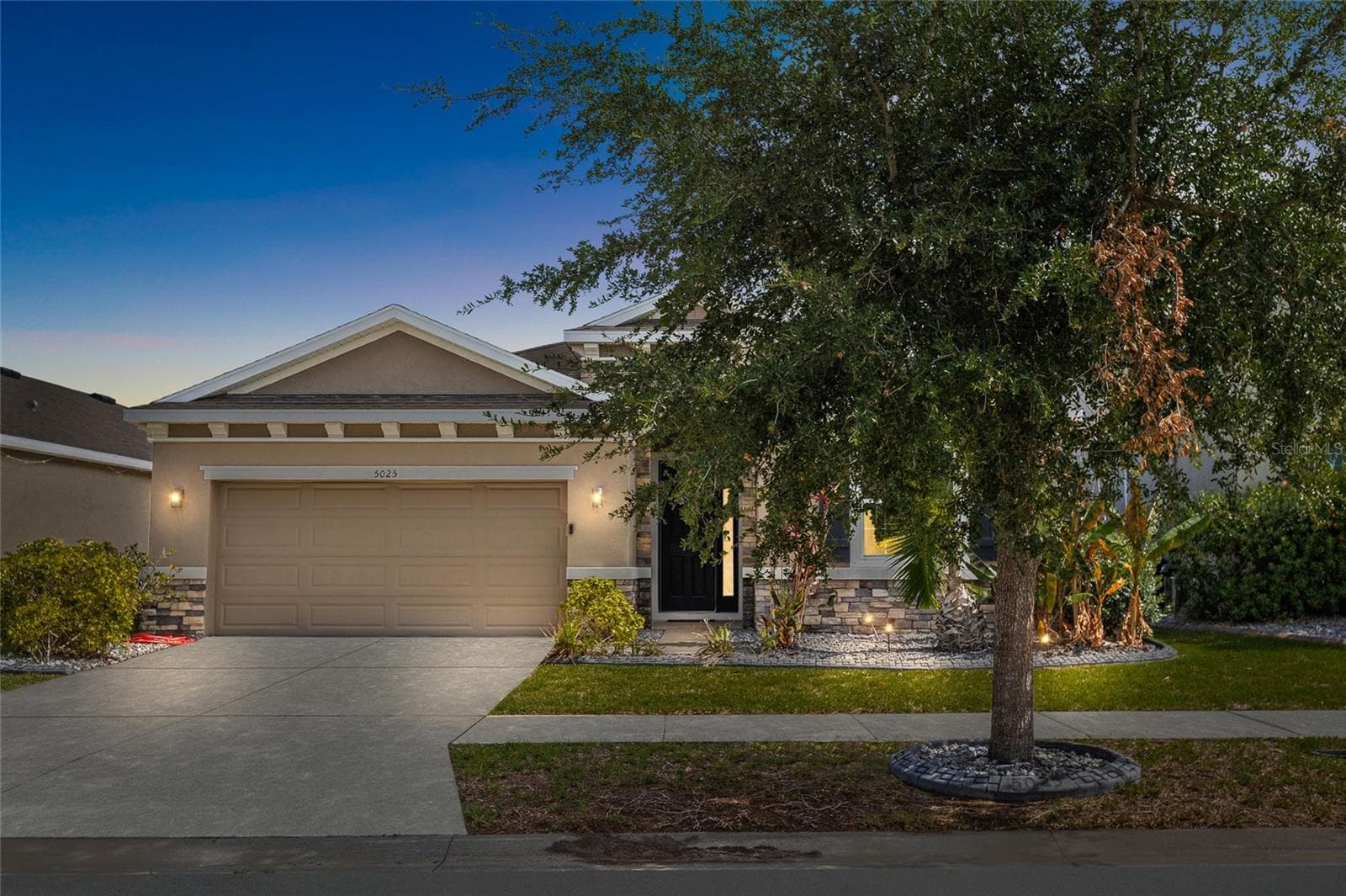 Welcome home to this beautifully maintained 4-bedroom, 2.5-bath home in Southshore Bay, featuring attractive curb appeal, professional landscaping, and a spacious 2-car garage. Built in 2018, this move-in-ready residence offers modern construction, energy efficiency, and a desirable location within one of Wimauma's most sought-after resort-style communities. The extended driveway and welcoming entry create a great first impression for both residents and guests. - 5025 JACKEL CHASE DR, WIMAUMA