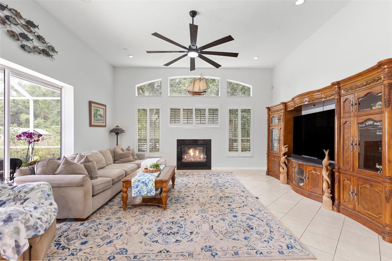 Family room features fireplace and plantation shutters - 8380 GOLDEN PRAIRIE DR, TAMPA