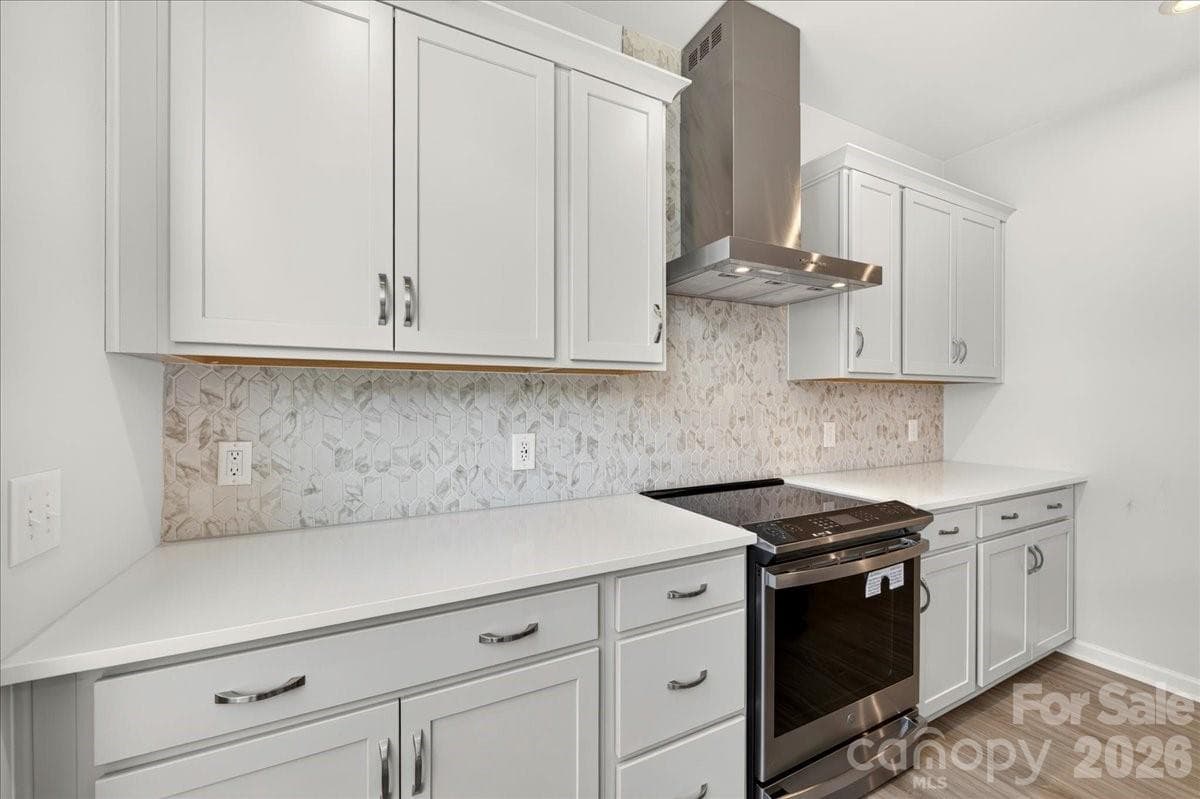 GE Profile 30" Slide-In Electric Range with a designer style stainless steel hood - Charlotte