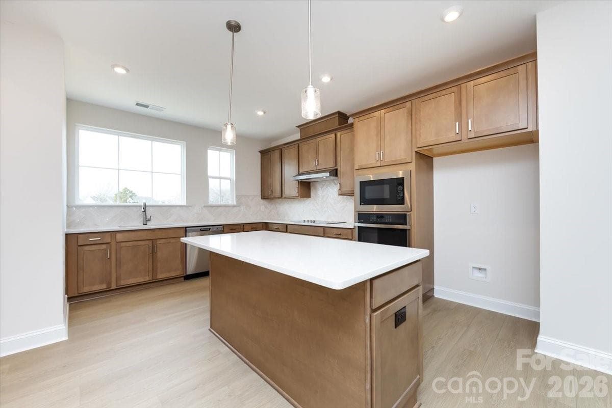 Gourmet kitchen with warm brown cabinets - Charlotte
