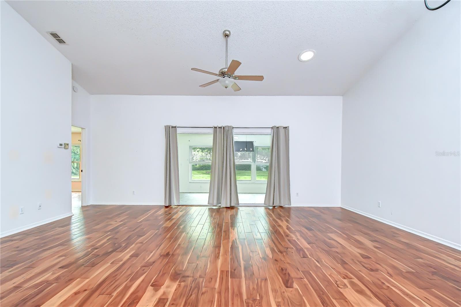 Spacious open-concept living area with soaring volume ceilings. - 818 MCCALLISTER AVE, SUN CITY CENTER
