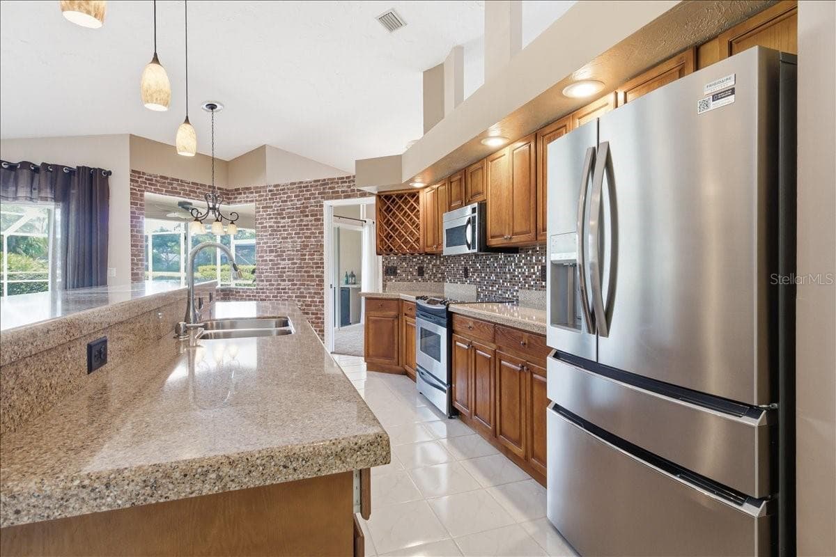 Huge freestanding kitchen bar/counter with sink and dishwasher under the quartz countertops - 7015 PLEASANT HILL RD, BRADENTON