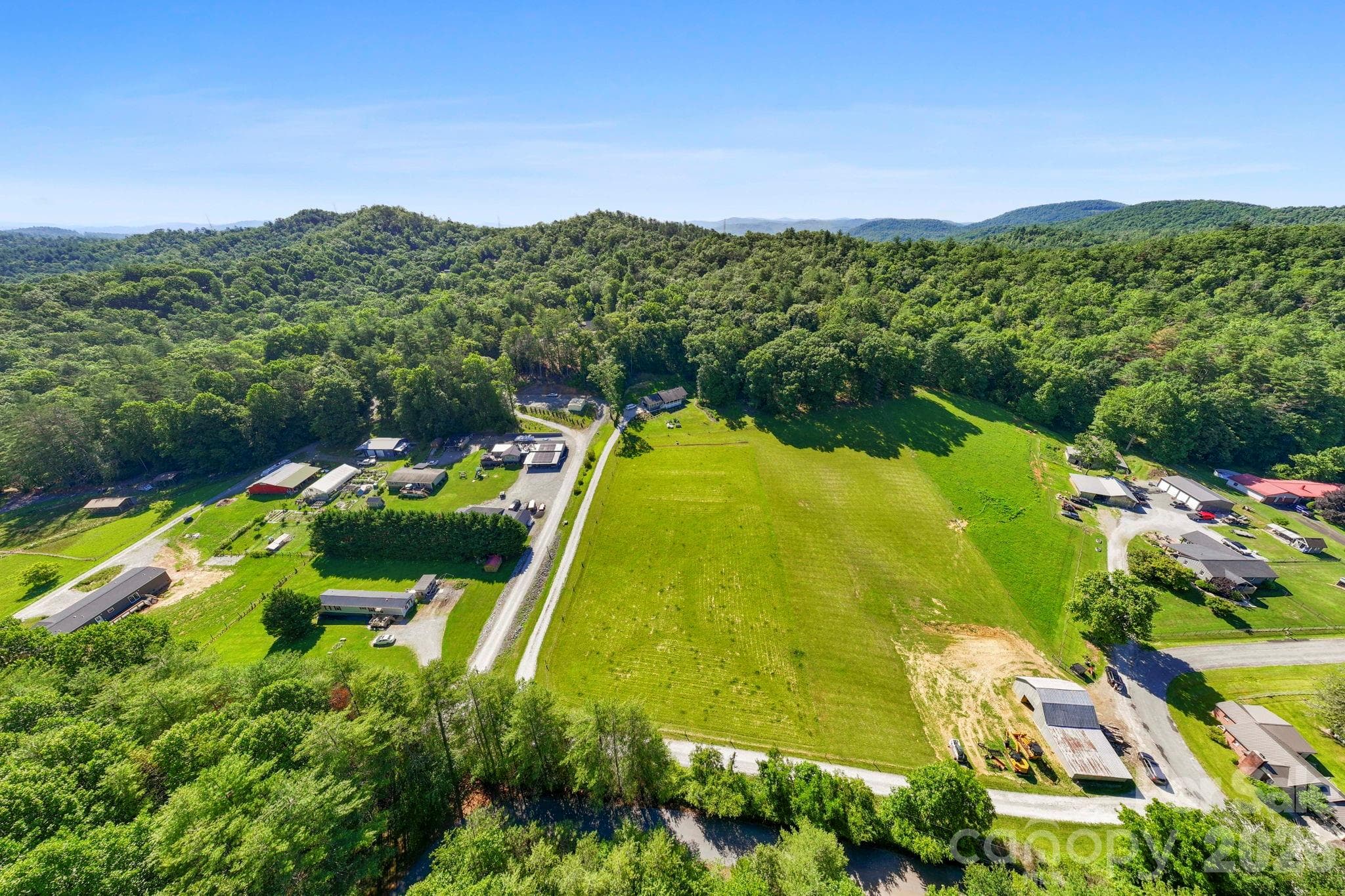 A breathtaking aerial view capturing the true essence of the valley. From this altitude, it's easy to spot the potential for several great home sites with mountain views, perfectly positioned to capture evening light. - Pisgah Forest