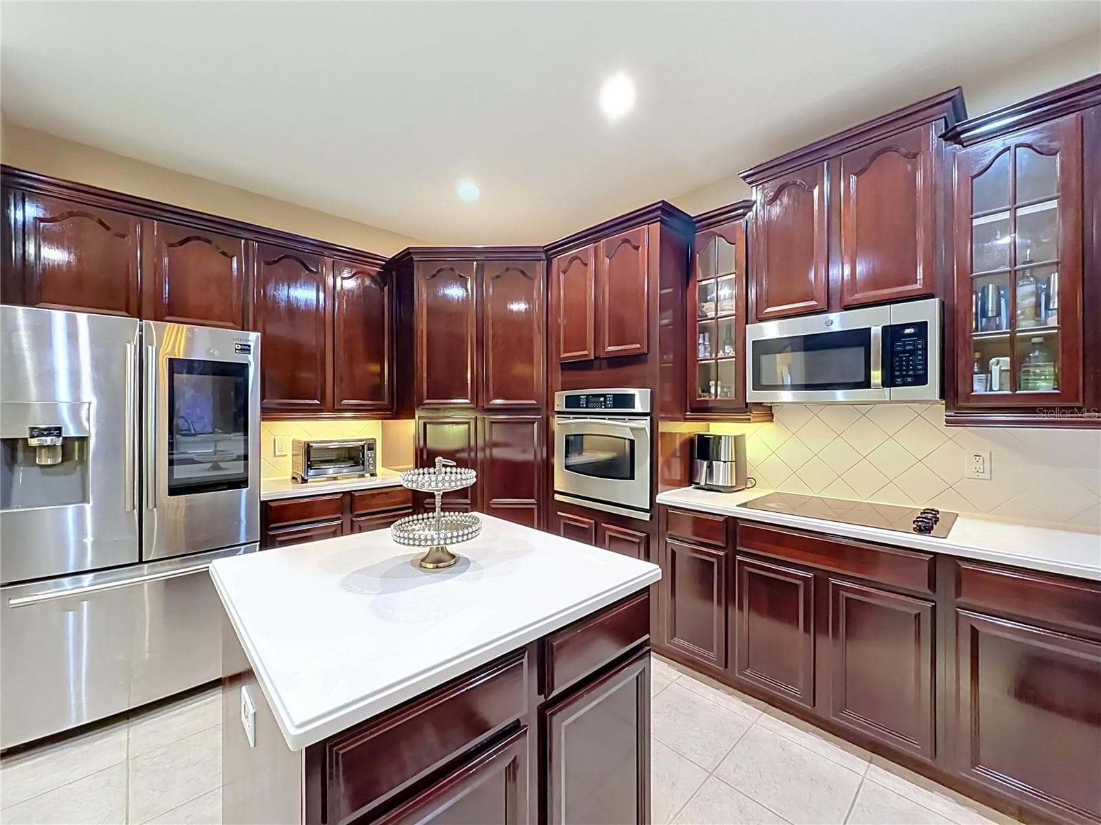 High end kitchen, refrigerator w/display, wall oven, microwave hood, cooktop, center island with loads of cabinets and prep space. - 3405 HEIRLOOM ROSE PL, OVIEDO