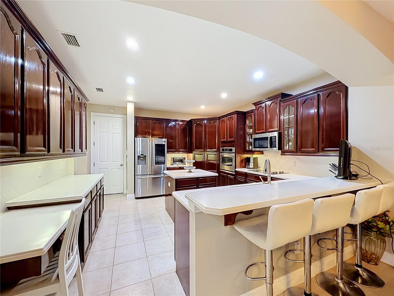Built in desk, loads of prep area, cabinets and bar seating. - 3405 HEIRLOOM ROSE PL, OVIEDO