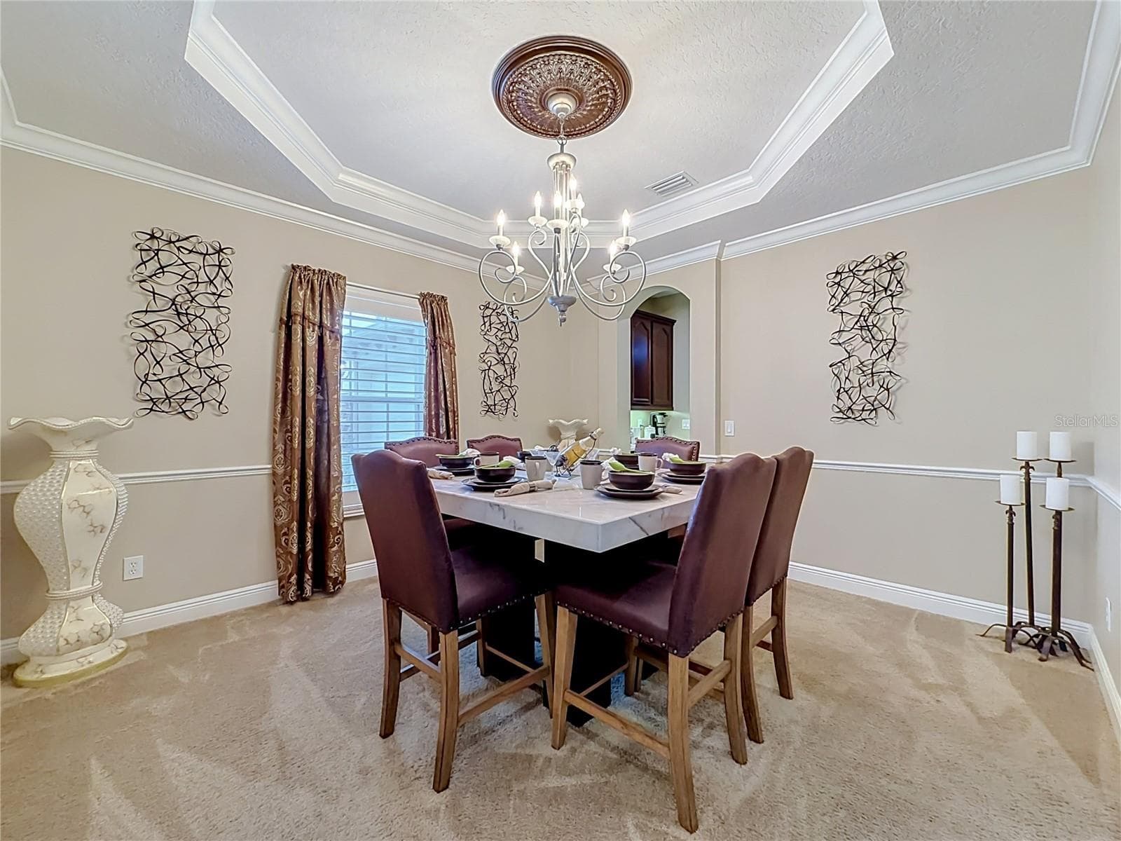 Formal dining area, Butler pantry access to kitchen, tray ceiling, crown molding and chair rail features. - 3405 HEIRLOOM ROSE PL, OVIEDO