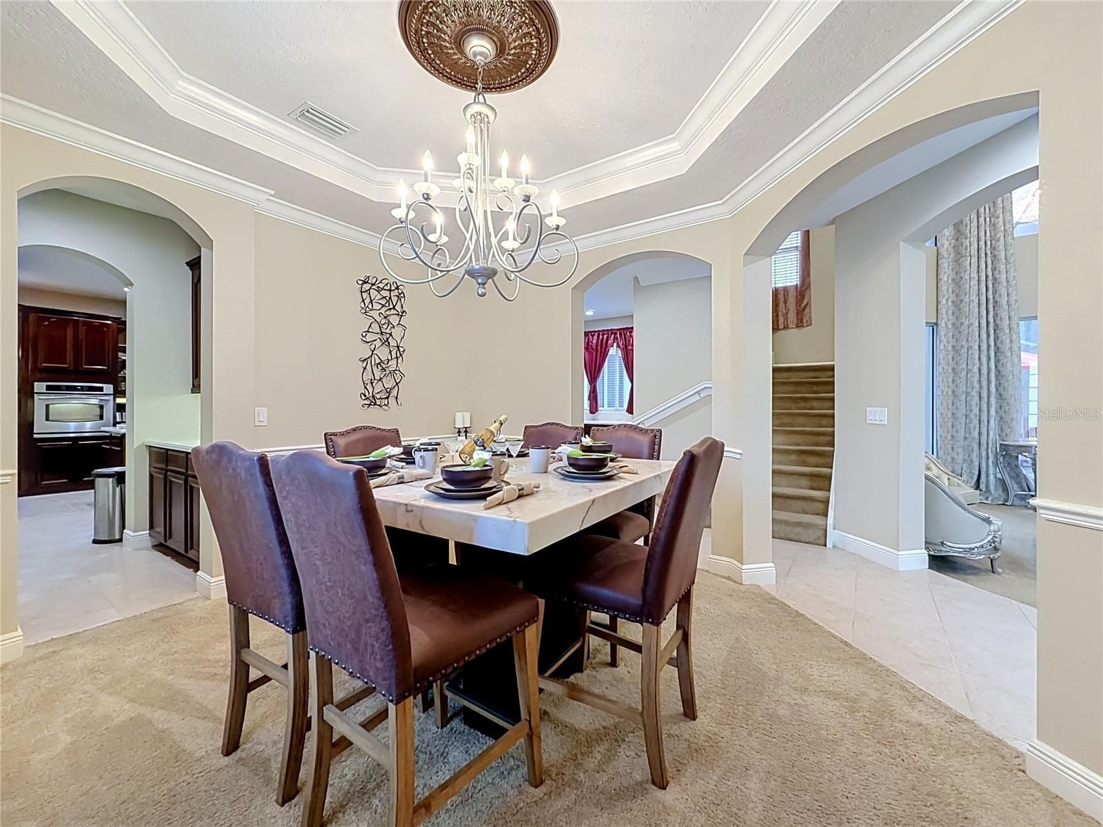 Formal dining area, Butler pantry to Kitchen, tray ceiling, crown and chair rail moldings. - 3405 HEIRLOOM ROSE PL, OVIEDO