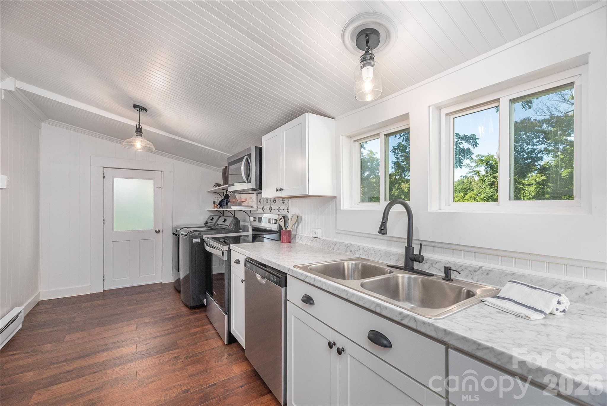 Kitchen features generous counter space, updated cabinetry, and backyard views. - Canton