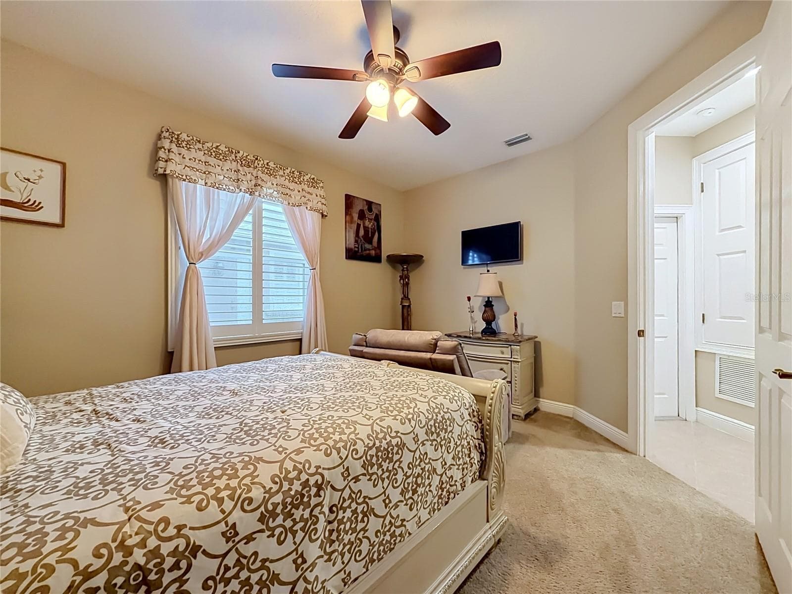 Downstairs bedroom 5, plantation shutters, walk-in closet, and private access to downstairs full bath. View towards door to one of two 2-car garages. - 3405 HEIRLOOM ROSE PL, OVIEDO