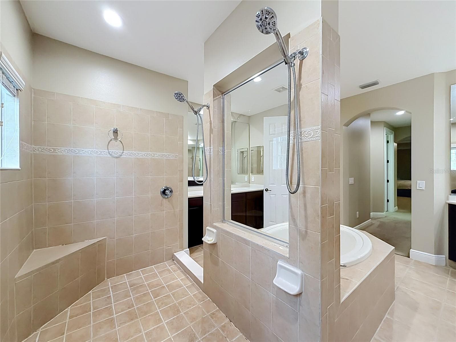 Large walk-in shower, multiple shower heads and built in bench seat. - 3405 HEIRLOOM ROSE PL, OVIEDO