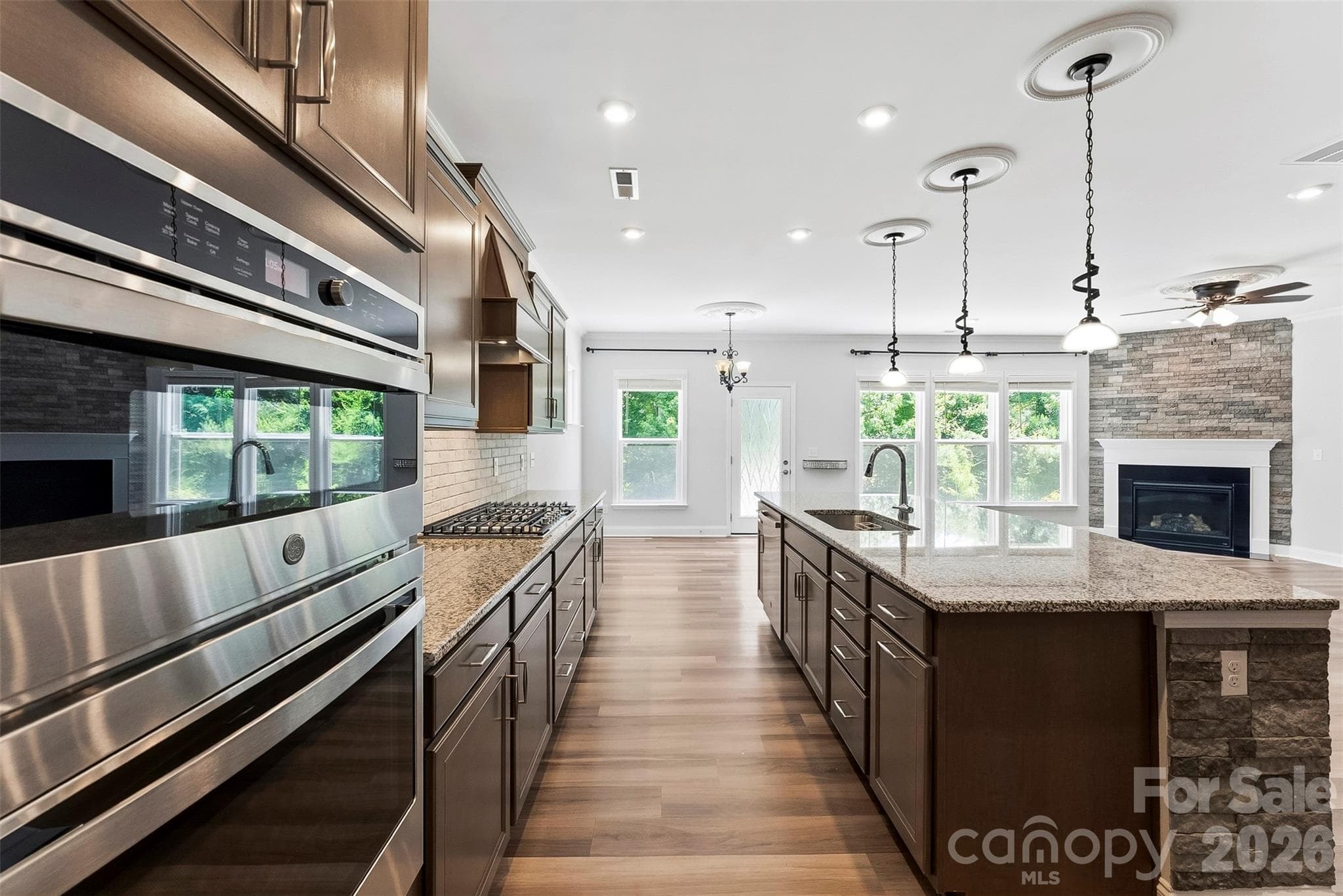 Upgraded, sleek and stylish this Chefs Gourmet Kitchen is sure to delight and make a wonderful location to entertain guests.  Built in Microwave/oven, gas cooktop, large chefs island with sink, granite countertops and tile backsplash, upgraded lighting, upgraded vent hood. - 1318 Poppy Way, Matthews