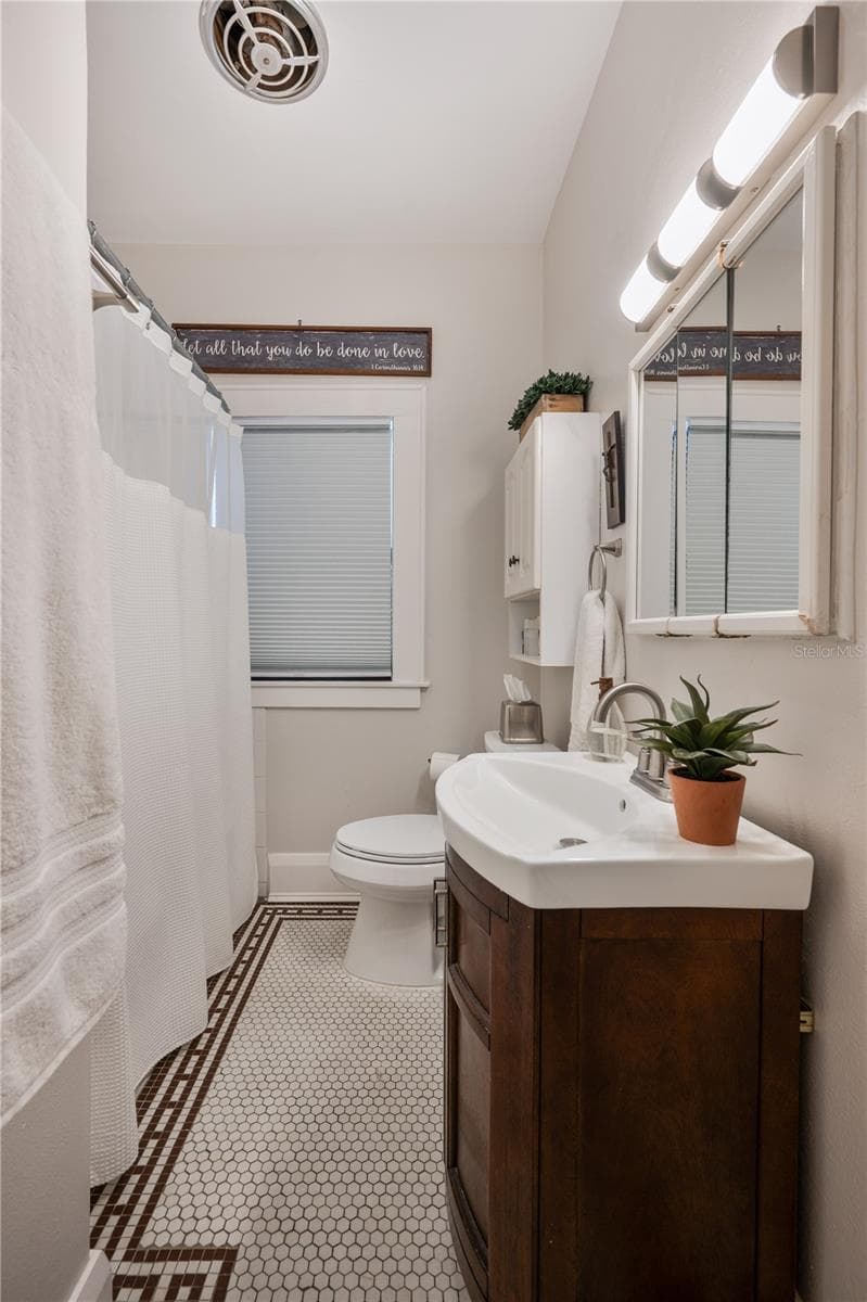 Bathroom 1 with tub-shower and original historic tile flooring - 1102 MELTON AVE, LAKELAND