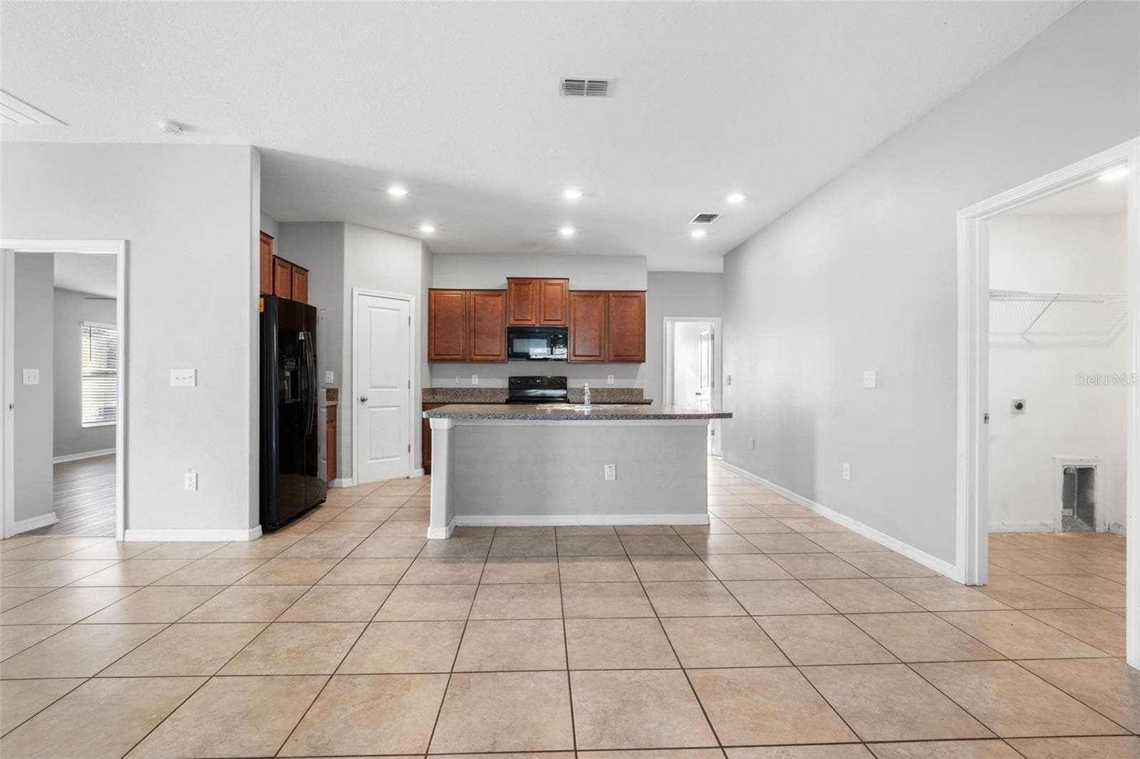 From the great room, the centrally located kitchen creates a natural hub with a spacious peninsula, recessed lighting, and easy access to the pantry, laundry room and garage. - 6810 TRENT CREEK DR, SUN CITY CENTER