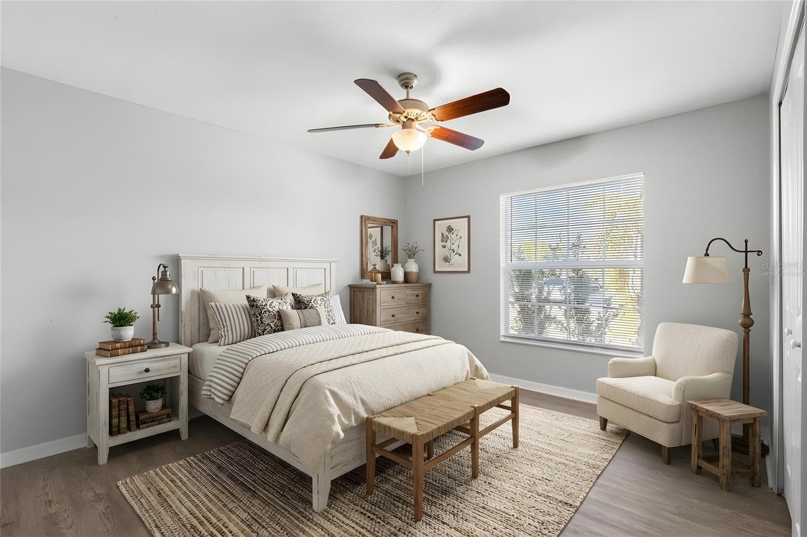 Bedroom 2 features laminate flooring, a ceiling fan, neutral tones, natural light, and a built-in closet. - 6810 TRENT CREEK DR, SUN CITY CENTER