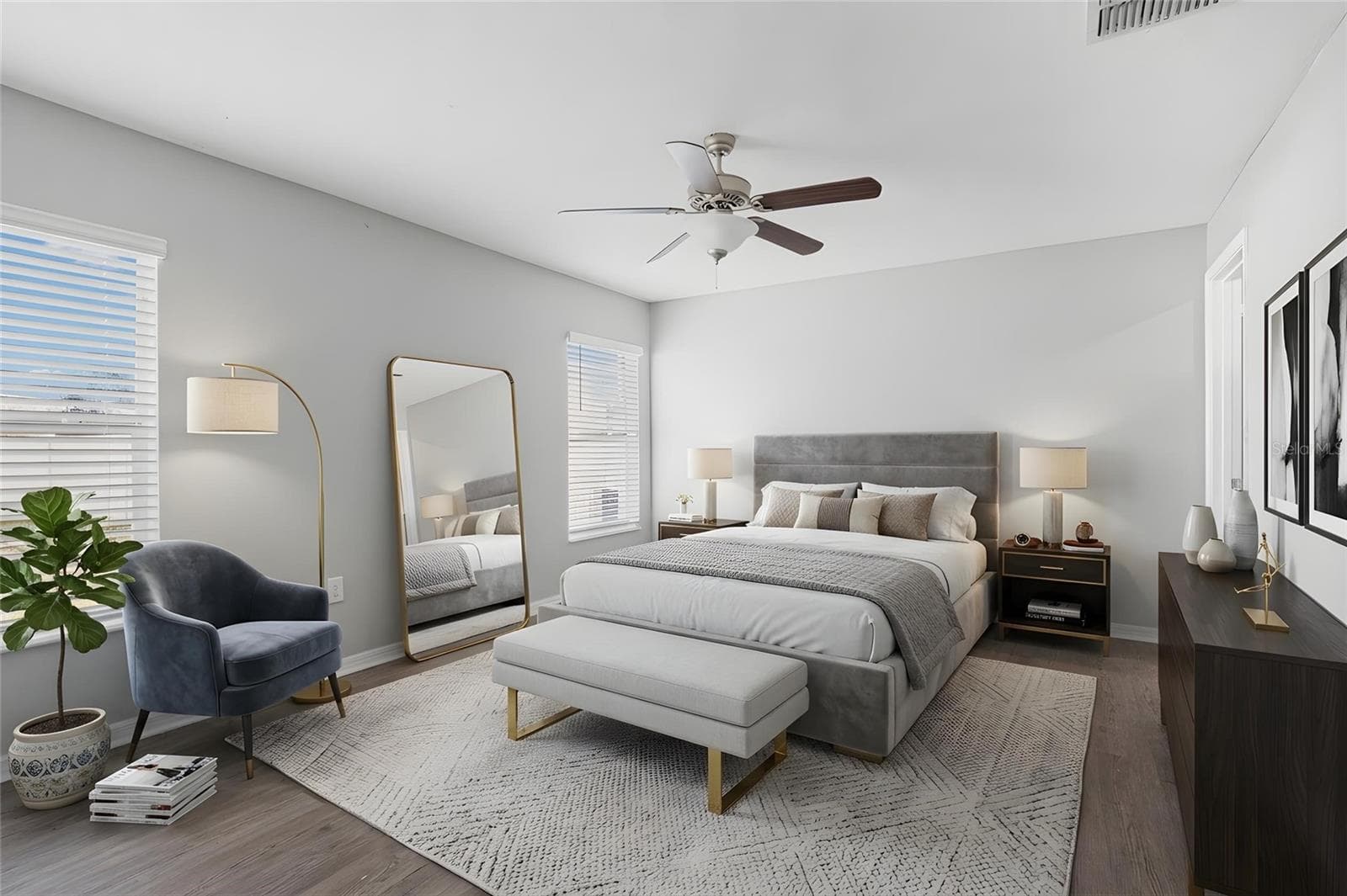 Two windows bring natural light into the spacious primary bedroom, which features laminate flooring, a ceiling fan, and room for a full furniture suite. - 6810 TRENT CREEK DR, SUN CITY CENTER
