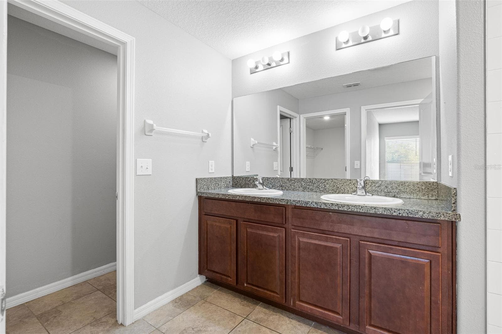 The primary bath features a tiled walk-in shower with a convenient handheld showerhead. - 6810 TRENT CREEK DR, SUN CITY CENTER
