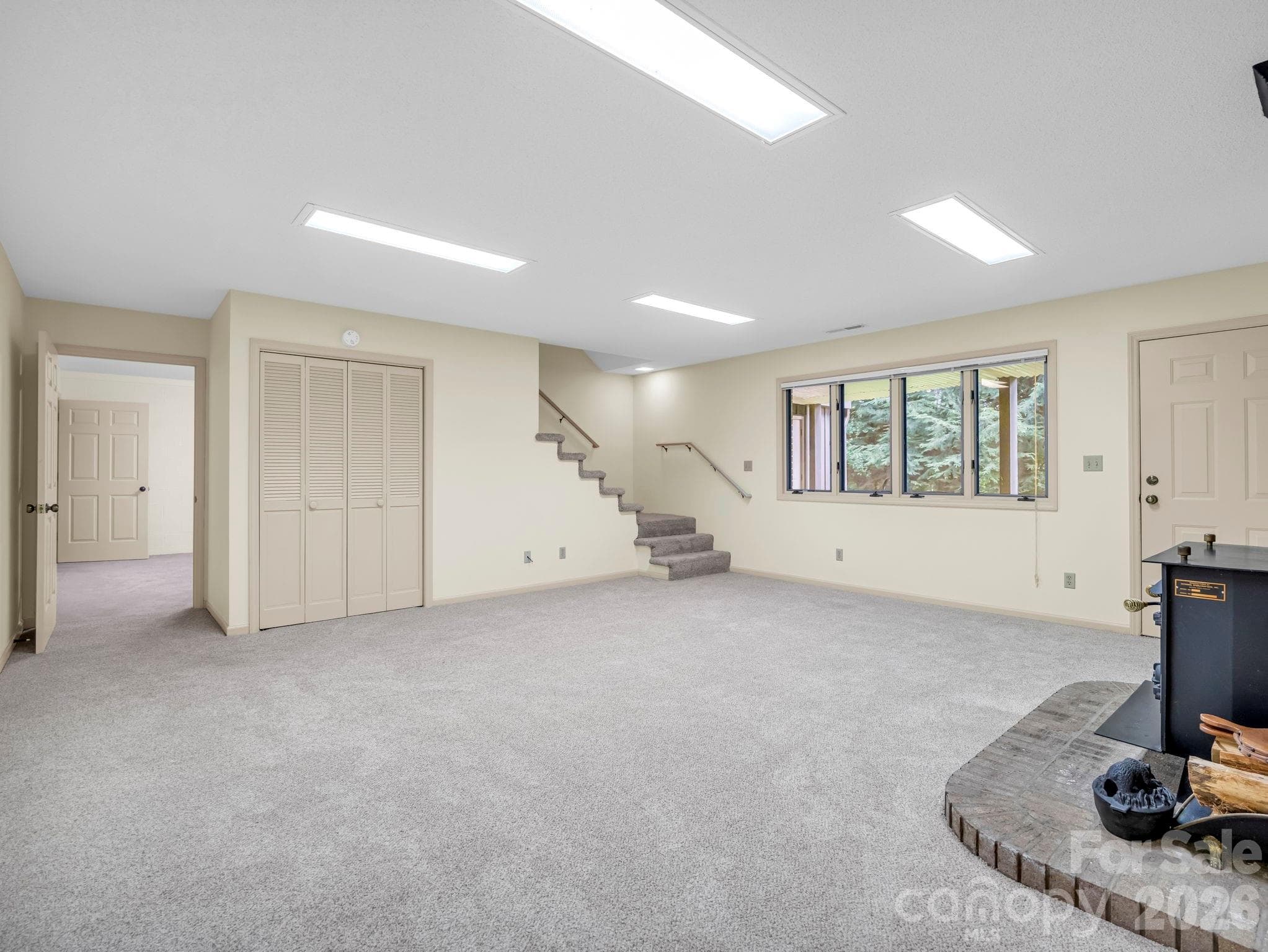 Lower Level family room  with wood burning fire place, door leads to fenced backyard - 115 Woodhaven Drive, Hendersonville