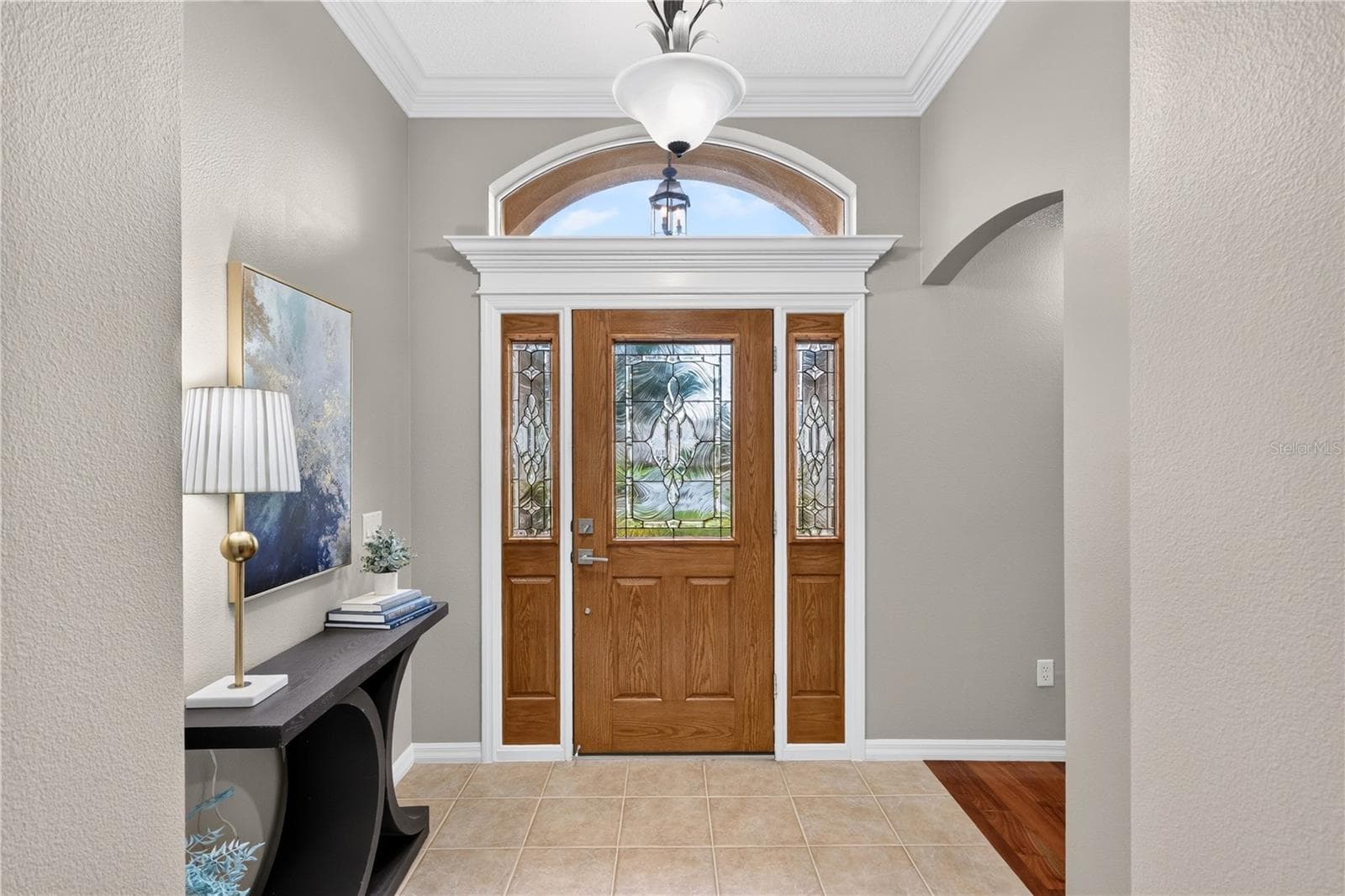 Elegant entry foyer with double glass front doors, tray ceiling detail, and a welcoming first impression. - 16815 SE 85TH BELKNAP AVE, THE VILLAGES