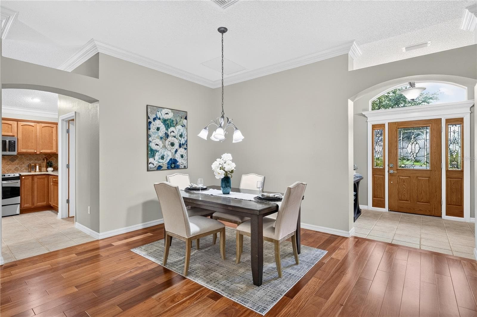 Formal dining space positioned near the front entry, featuring pendant lighting, neutral finishes, and access to the kitchen. - 16815 SE 85TH BELKNAP AVE, THE VILLAGES