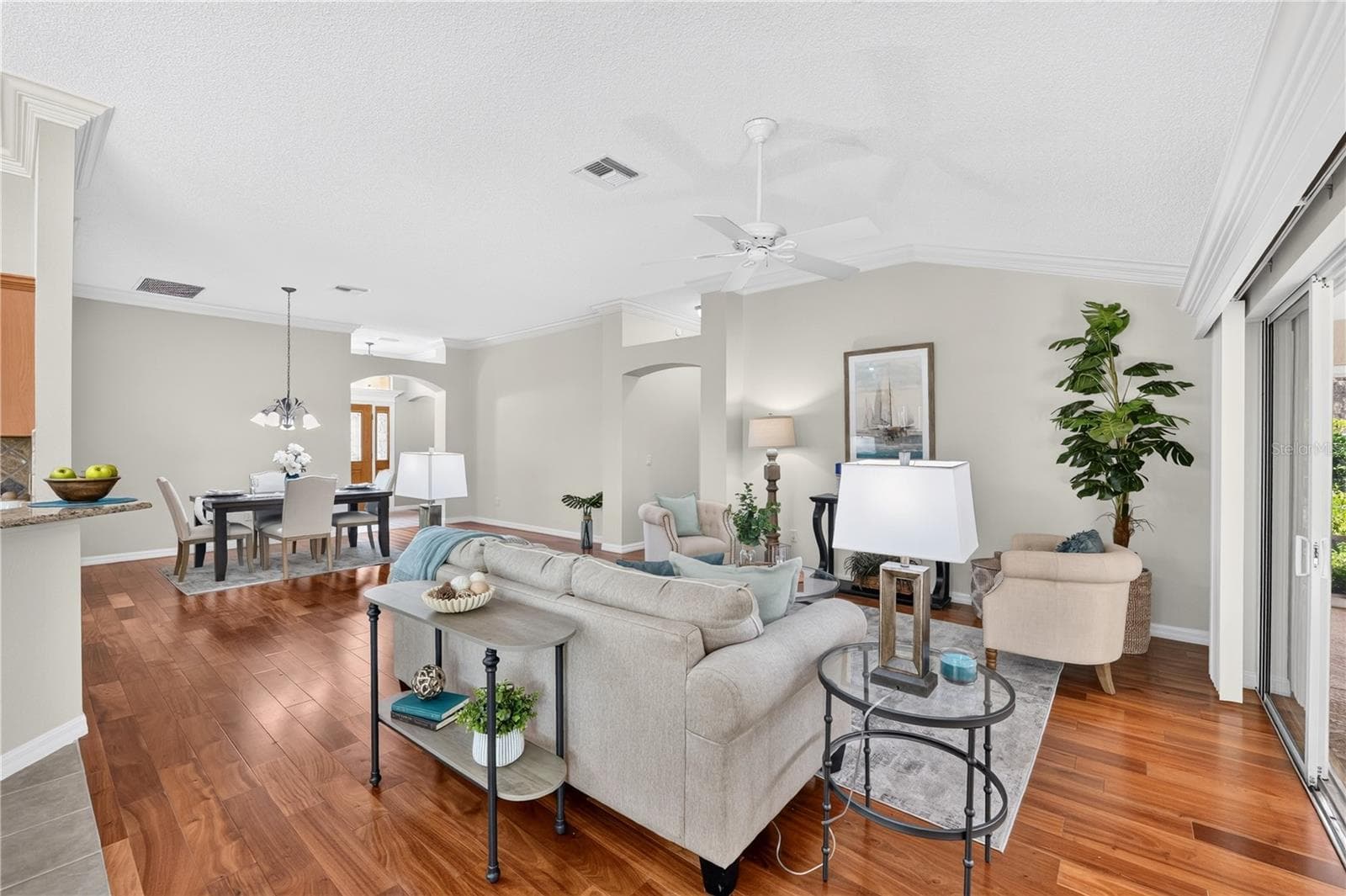 Spacious open-concept living area featuring high ceilings, abundant natural light, and sliding glass doors to the lanai. - 16815 SE 85TH BELKNAP AVE, THE VILLAGES