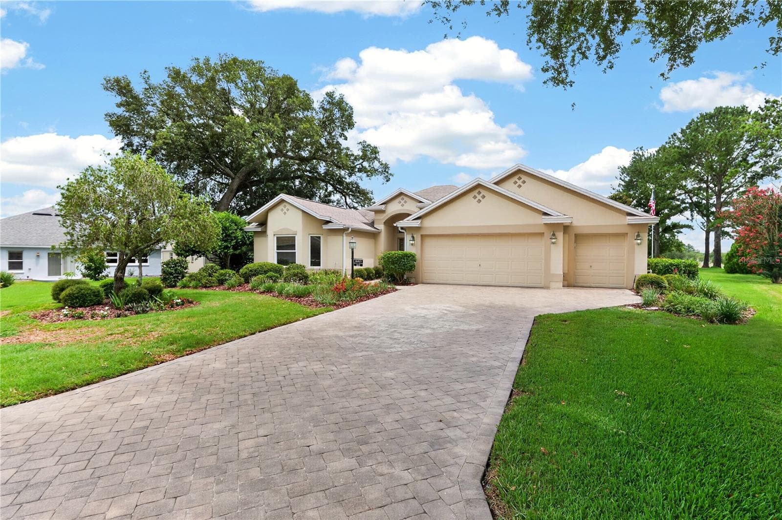 Welcoming front approach with manicured lawn, mature shade trees, spacious driveway, and beautifully maintained exterior. - 16815 SE 85TH BELKNAP AVE, THE VILLAGES