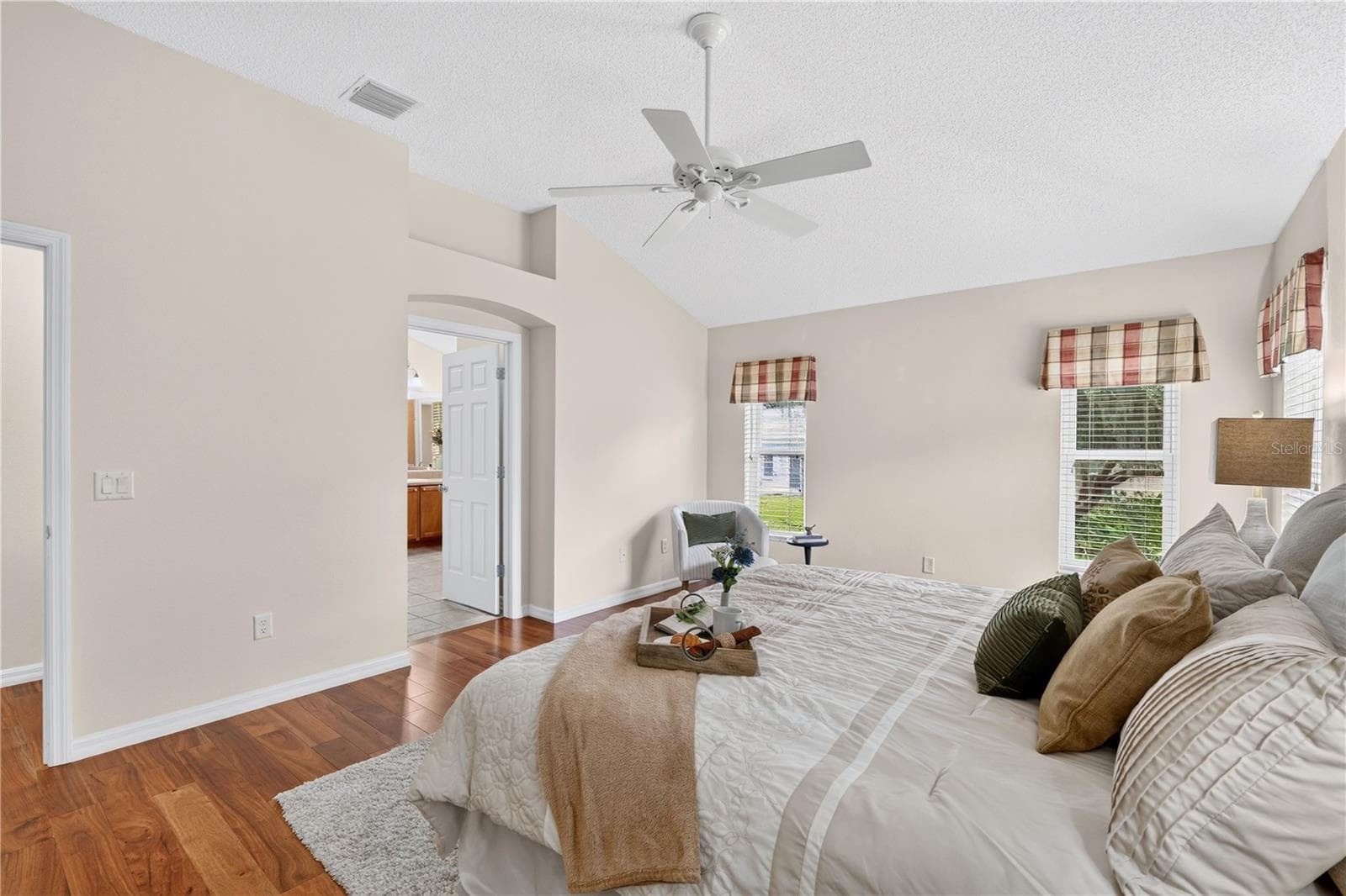 Primary suite view highlighting the generous room size, neutral finishes, and private access toward the en-suite bath. - 16815 SE 85TH BELKNAP AVE, THE VILLAGES
