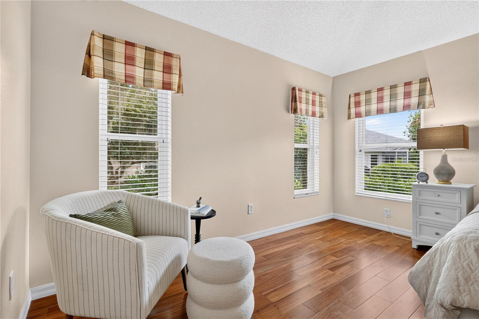 Comfortable sitting area within the primary bedroom, framed by bright windows and peaceful outdoor views. - 16815 SE 85TH BELKNAP AVE, THE VILLAGES