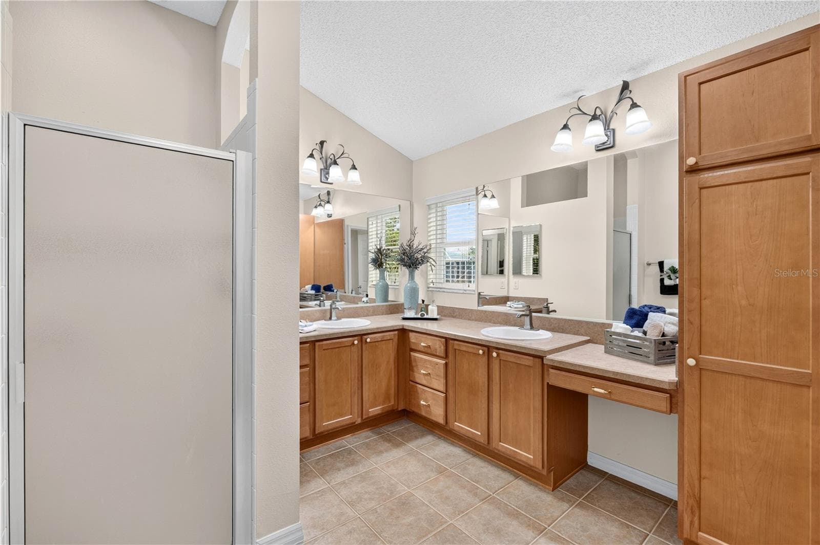 Primary bathroom view showcasing dual vanities, wood cabinetry, generous counter space, and a bright, spacious layout. - 16815 SE 85TH BELKNAP AVE, THE VILLAGES