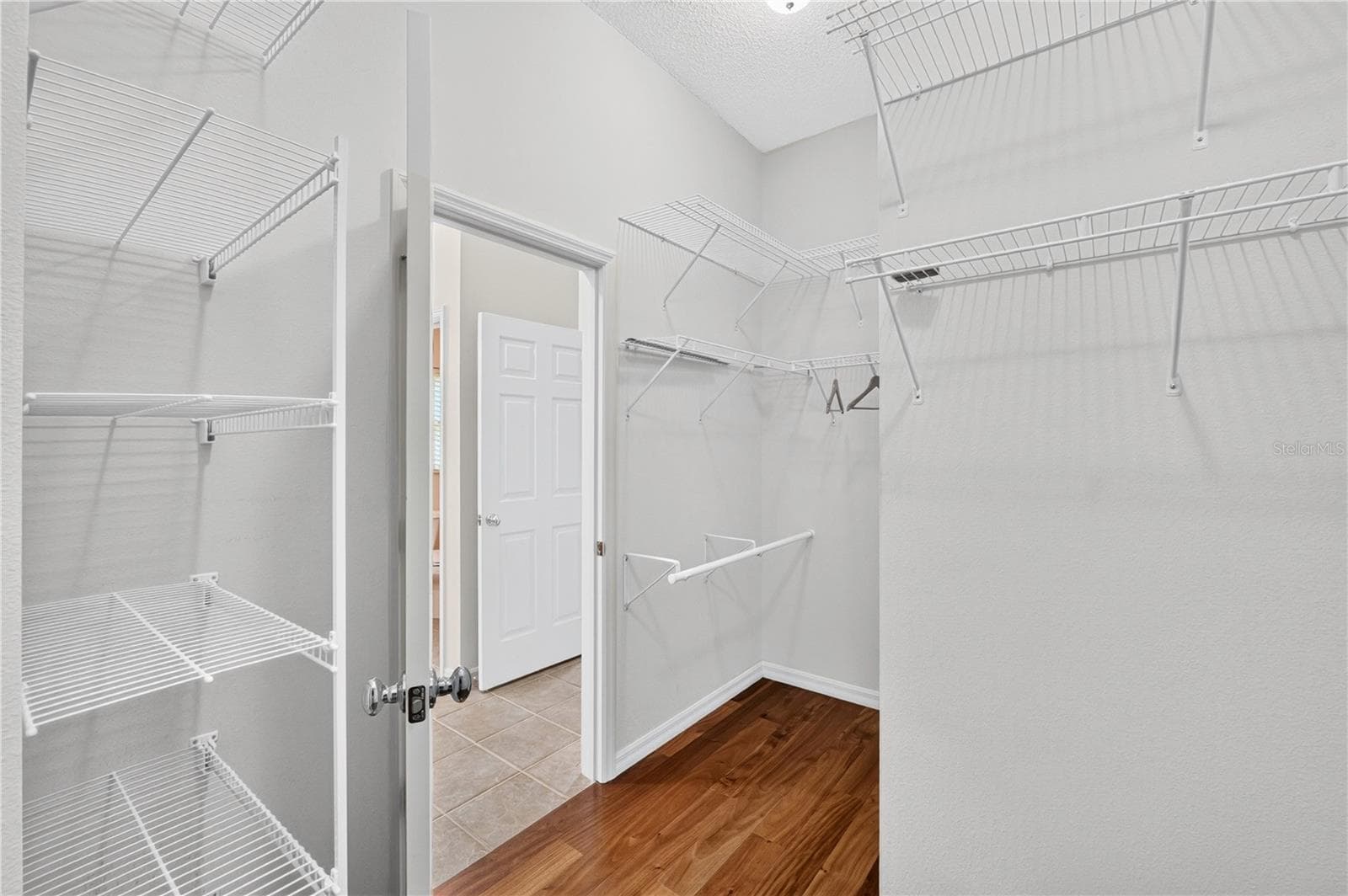 Spacious walk-in closet with built-in shelving and hanging space, offering practical organization and storage. - 16815 SE 85TH BELKNAP AVE, THE VILLAGES
