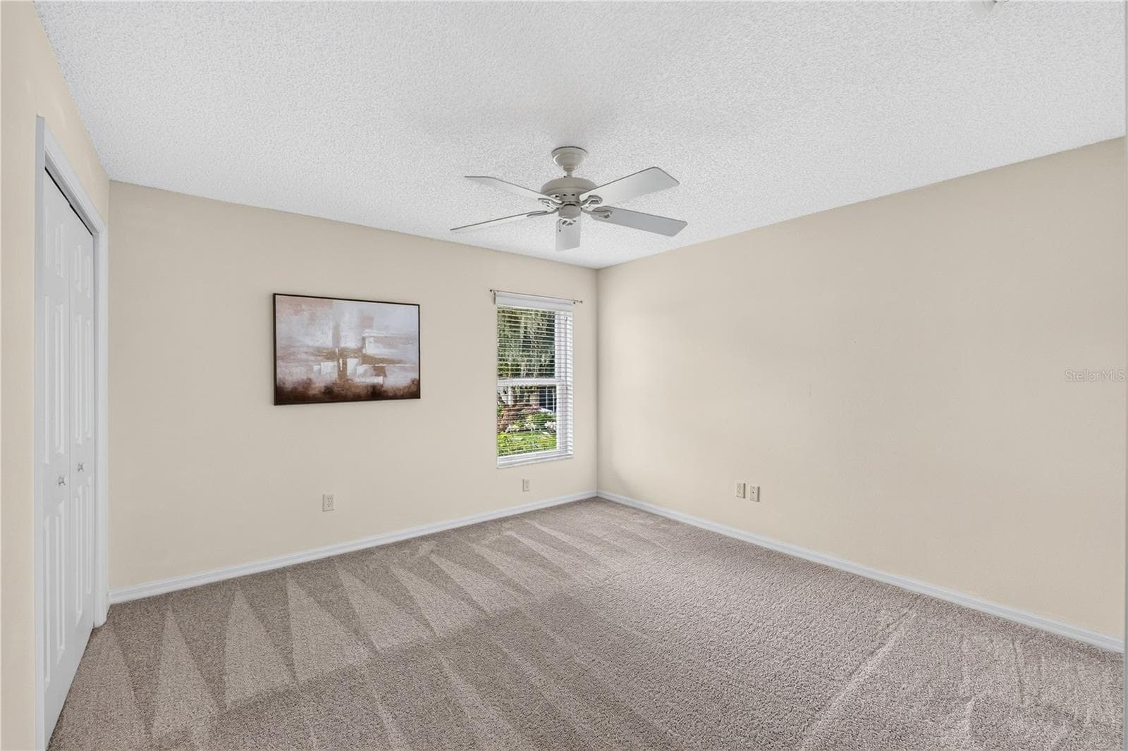 Additional guest bedroom with soft BRAND NEW neutral carpeting, ceiling fan, closet storage, and natural light. - 16815 SE 85TH BELKNAP AVE, THE VILLAGES