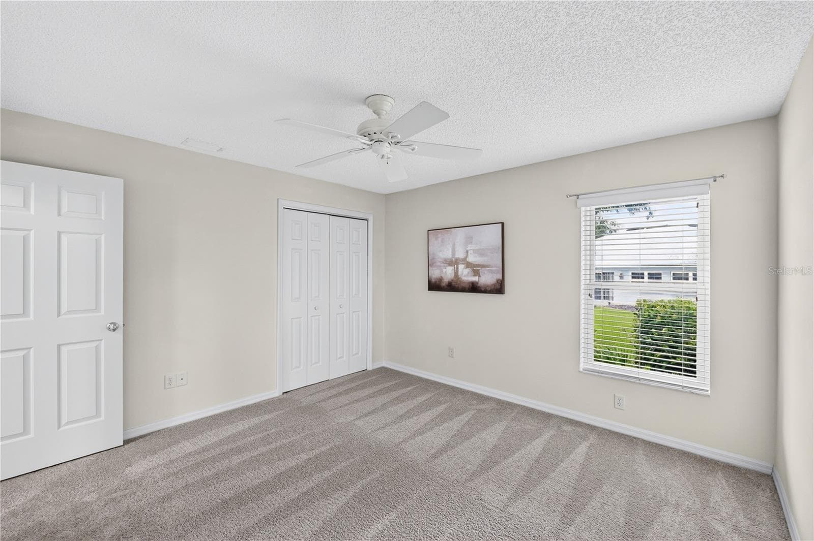 Comfortable guest bedroom with neutral tones, window views, and flexible space for family, visitors, or office use. (BRAND NEW CARPETING!) - 16815 SE 85TH BELKNAP AVE, THE VILLAGES