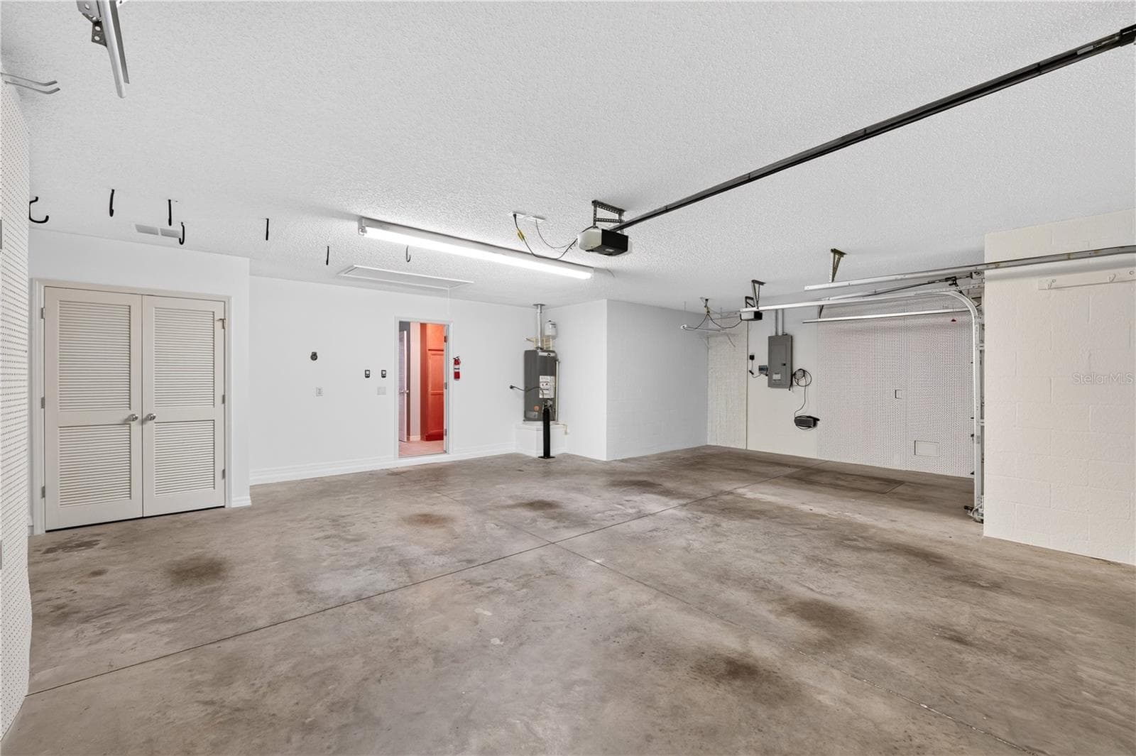 Spacious garage with room for golf carts, vehicles, storage, hobbies, or workspace, plus convenient side/service door access. - 16815 SE 85TH BELKNAP AVE, THE VILLAGES