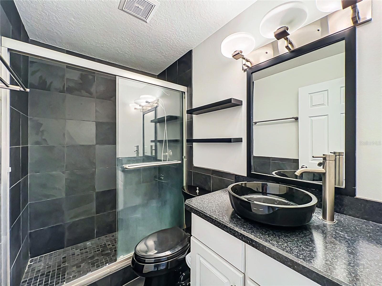 Updated bathroom featuring a walk-in shower; no bathtub present. - 554 WHITTINGHAM PL, LAKE MARY