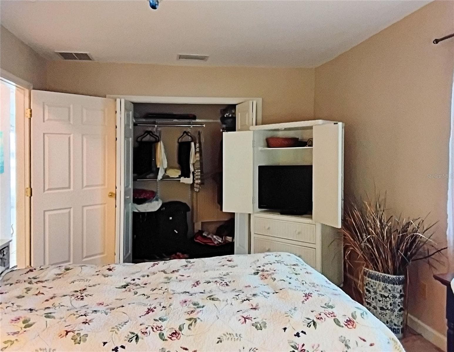 Large closet and television cabinet in primary bedroom - 2440 ELKCAM BLVD, PORT CHARLOTTE