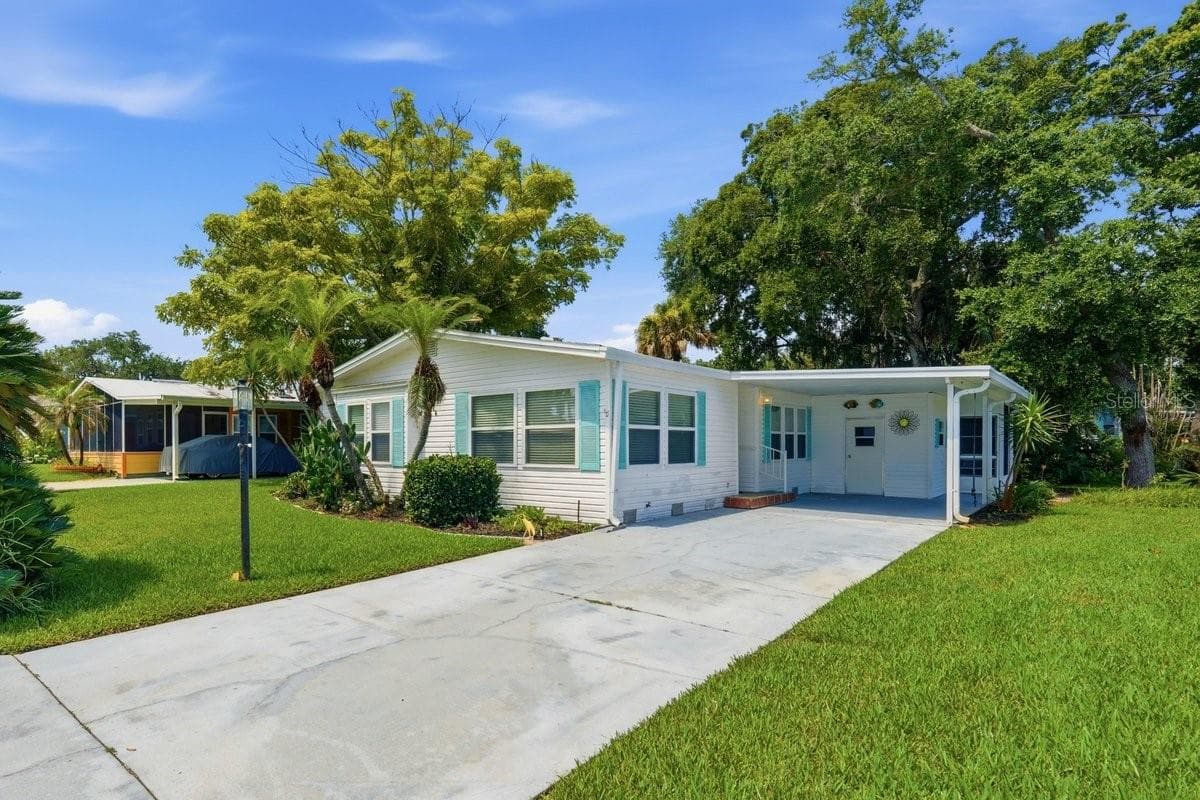 Front of Home showing Carport, Storage. Notice the long driveway - 304 PORTSIDE LN, EDGEWATER
