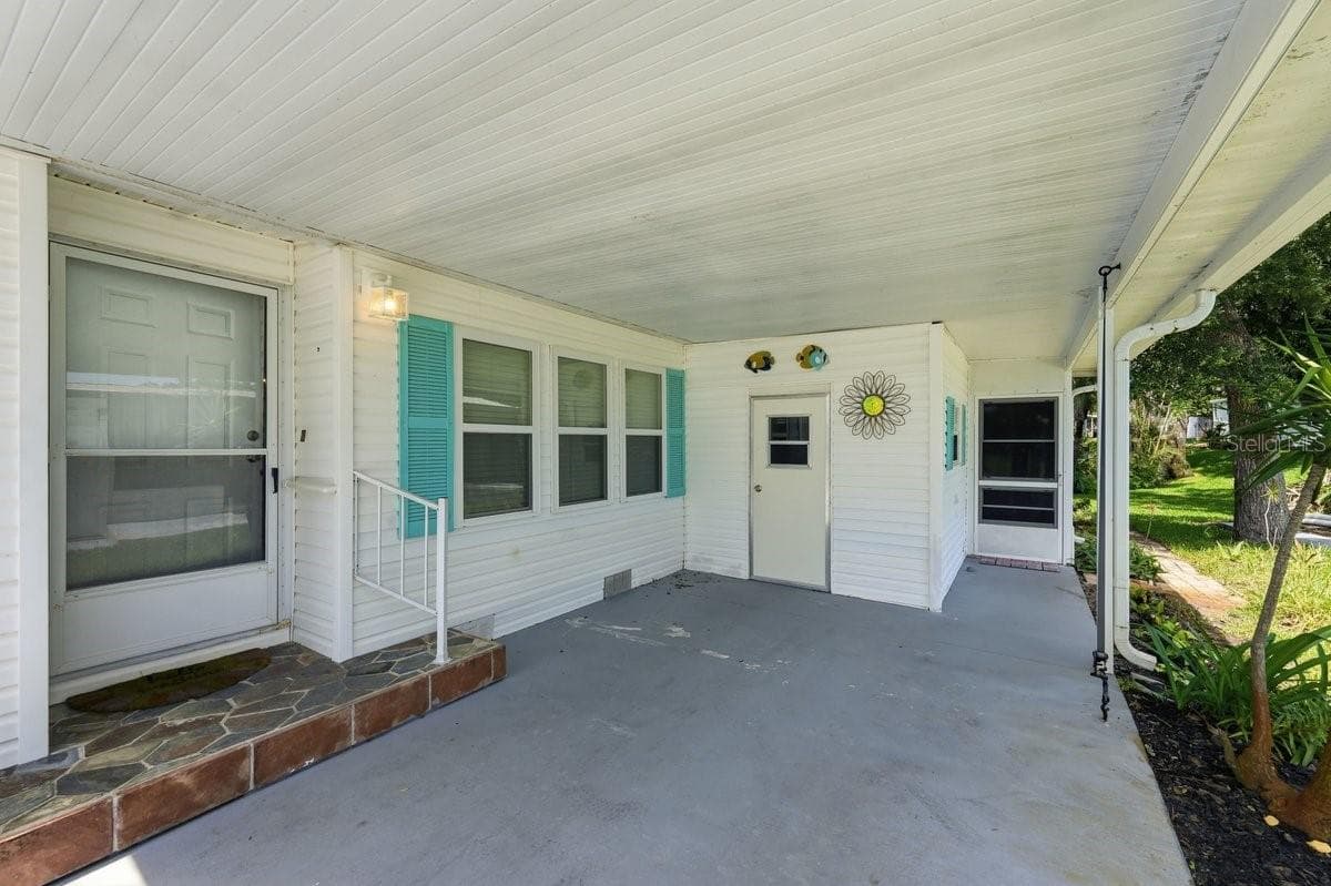 On Carport showing Front door to the left, Carport Storage in Rear; and Florida Room on Right. Notice the great Hurricane tie downs on the carport. Gutters. - 304 PORTSIDE LN, EDGEWATER