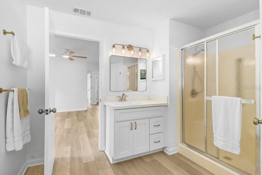 Primary Bath with step in shower, separate toilet closet and large walk in closet. New vanity, mirror, lighting and toilet. - 4949 PLEASANT HOLLOW TRL #211, LAKELAND