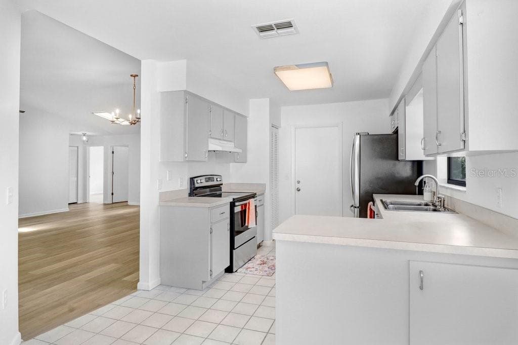 Dinette & Kitchen open to Living/Dining on the left.  Both have  sliding glass doors opening to enclosed patio. Door to right opens to two car garage with storage. - 4949 PLEASANT HOLLOW TRL #211, LAKELAND