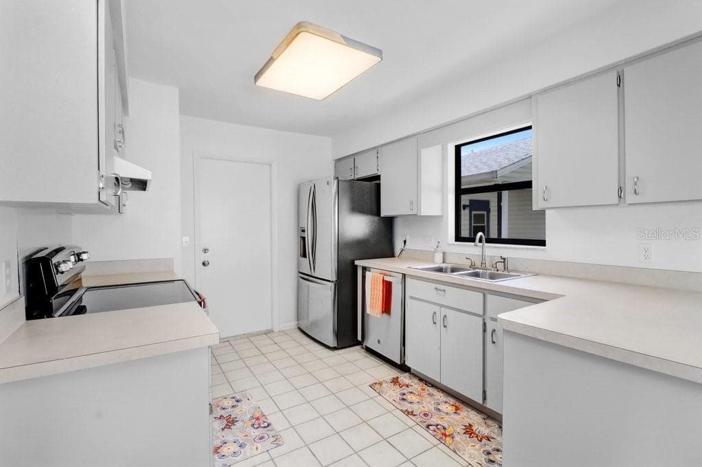 Kitchen ~ with new light fixture, new cabinet hinges and pulls,  and newer stainless steel appliances ~ opens to/adjacent to dinette - 4949 PLEASANT HOLLOW TRL #211, LAKELAND