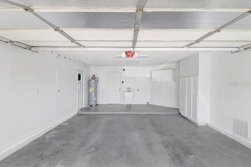 Two car garage with sink  & storage cabinets. Side access door to the left. - 4949 PLEASANT HOLLOW TRL #211, LAKELAND
