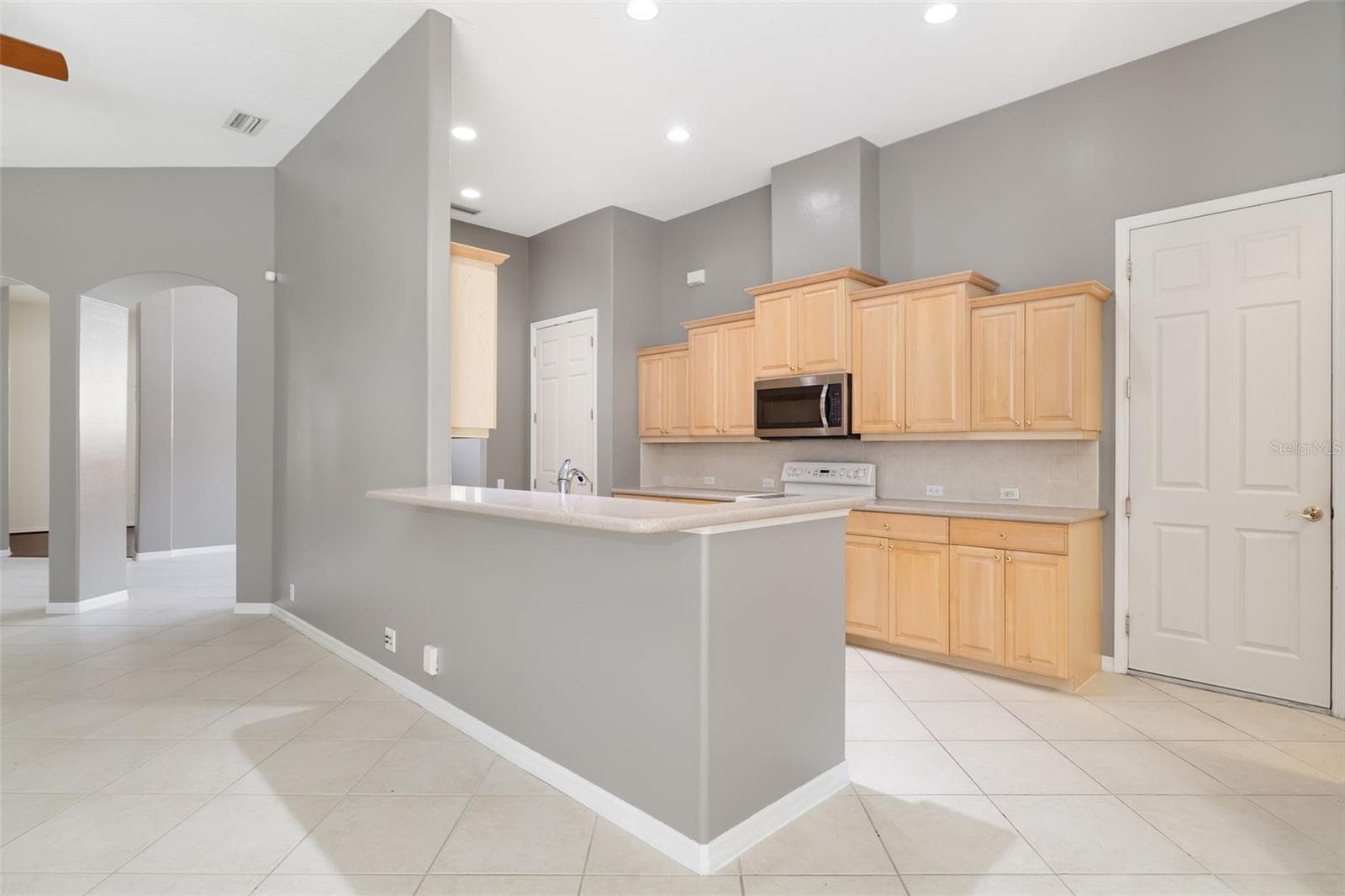 Open kitchen with 42 inch stacked, wood cabinetry - 4770 MAINSAIL DR, BRADENTON