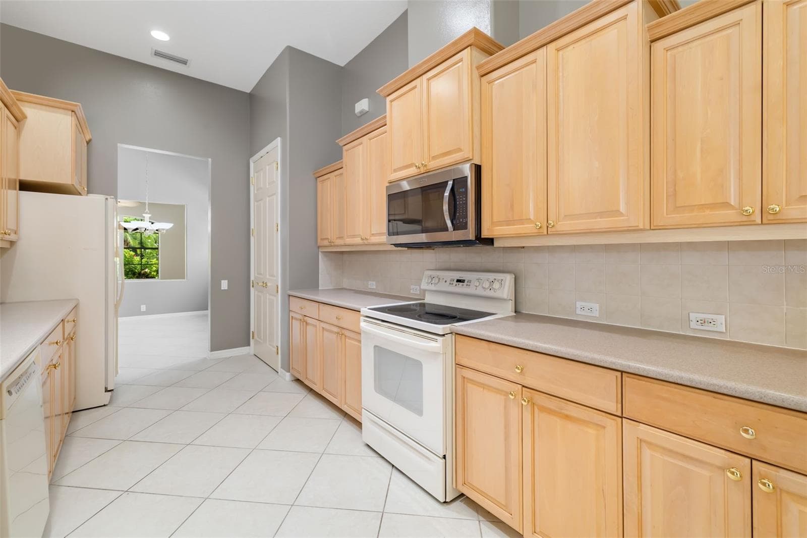 Spacious kitchen with plenty of storage cabinetry, large pantry - 4770 MAINSAIL DR, BRADENTON