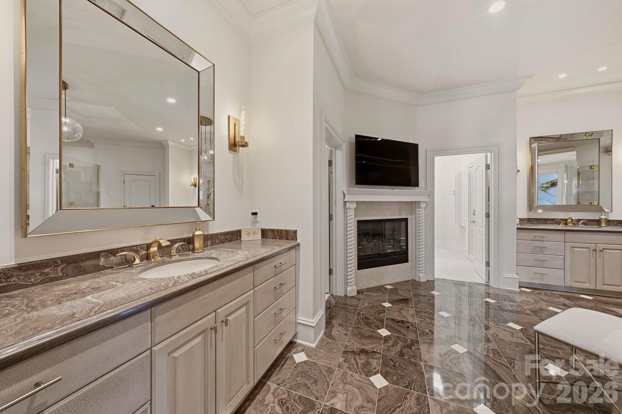 Main-level primary ensuite with two vanities, fireplace, and private water closet. - 16920 Harbor Master Cove, Cornelius