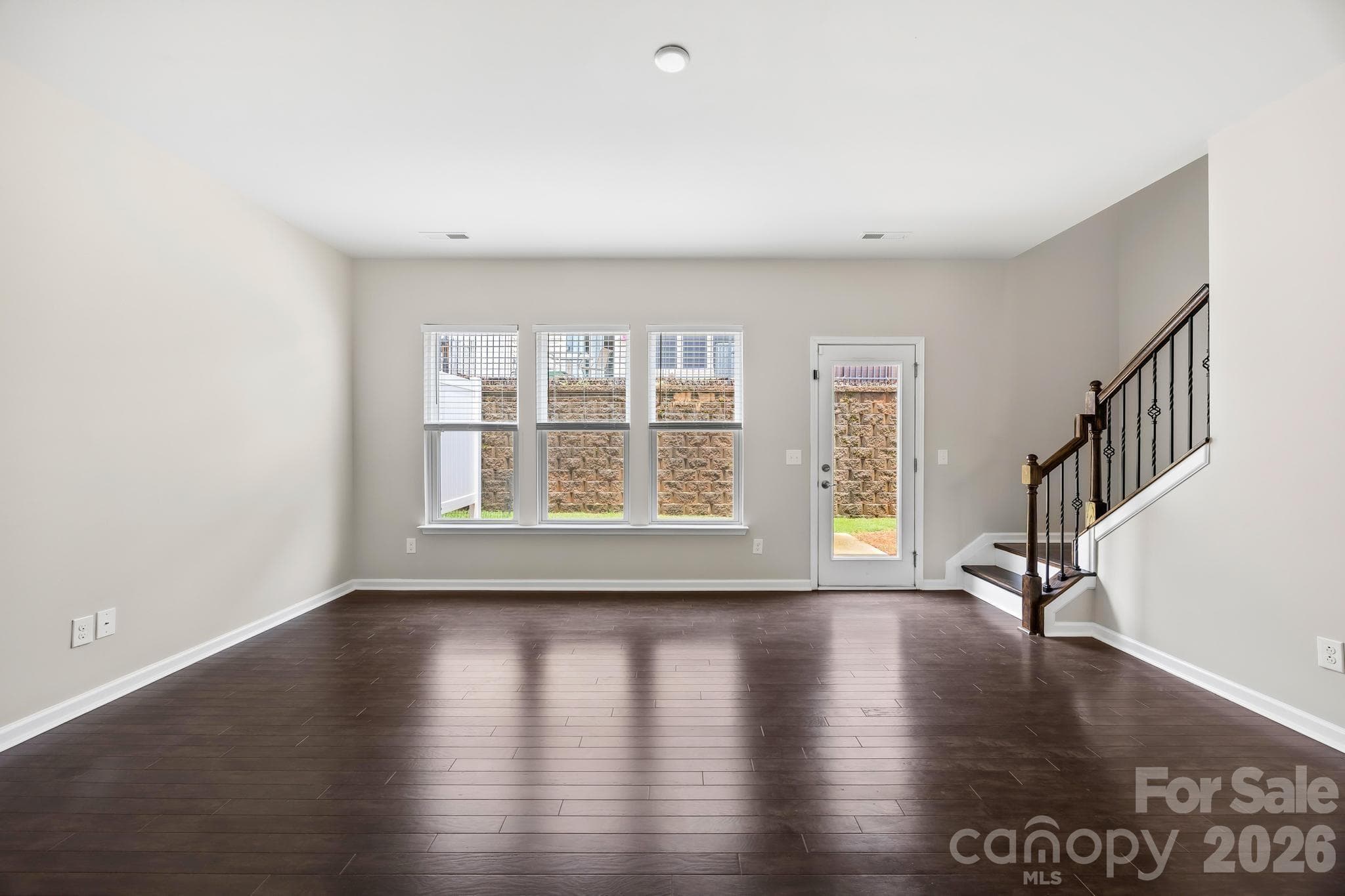 The spacious living room is filled with natural light and anchored by a cozy gas fireplace, creating the perfect space to relax or entertain. - Charlotte