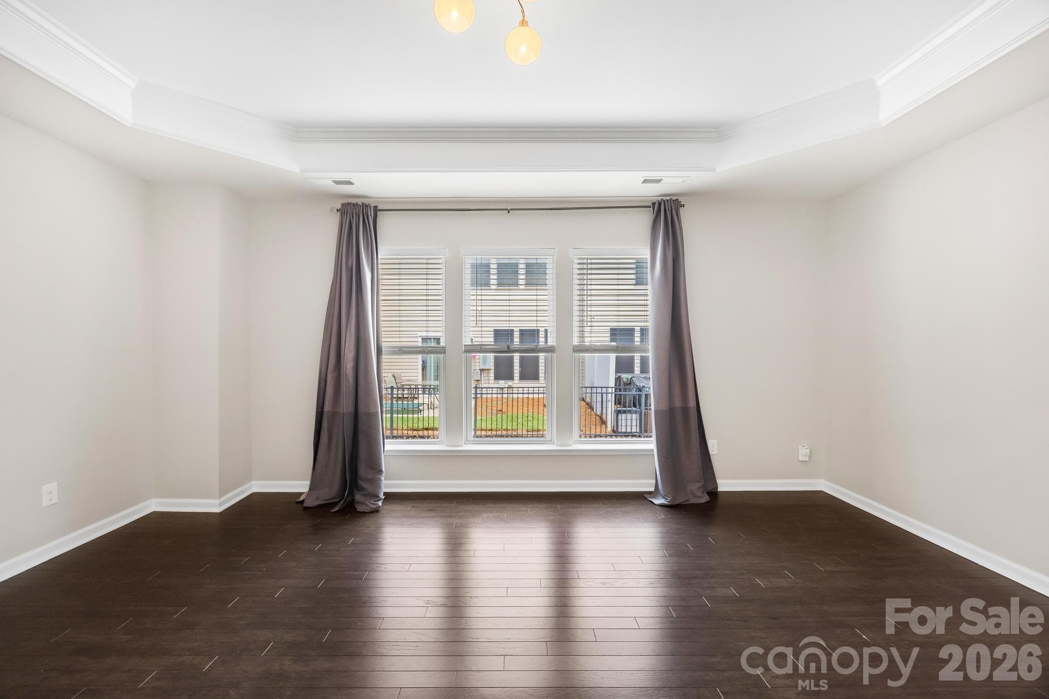 Retreat to the spacious primary suite featuring an elegant tray ceiling and plenty of room to unwind. - Charlotte