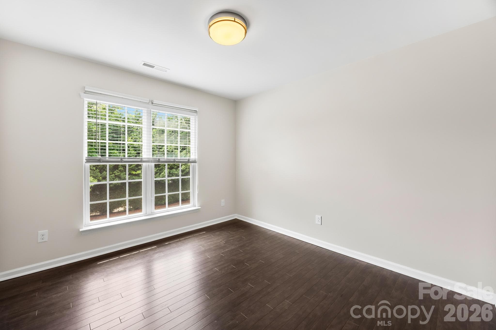 A bright and versatile secondary bedroom is ideal for family, guests, or a home office. - Charlotte