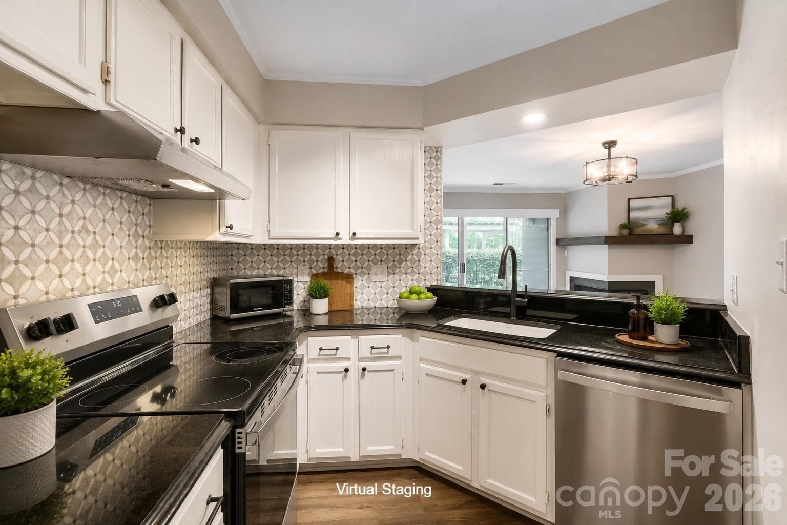 Dark granite countertops contrast beautifully with white cabinetry and a striking mosaic backsplash in this fully updated kitchen. A pass-through view to the living room's fireplace keeps the space feeling open and connected. - Charlotte