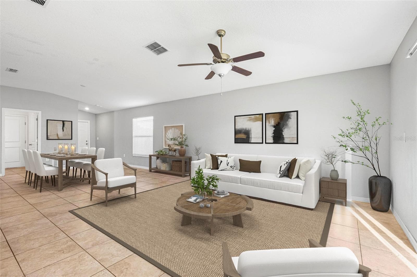 Great room featuring ceramic tile flooring, ceiling fan, and sliding glass doors that open to a fenced backyard, filling the space with natural light. - 6810 TRENT CREEK DR, SUN CITY CENTER
